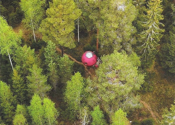 Flygfoto över Supermåne, den röda sfären gömd bland trädkronorna i Furudals skogar.