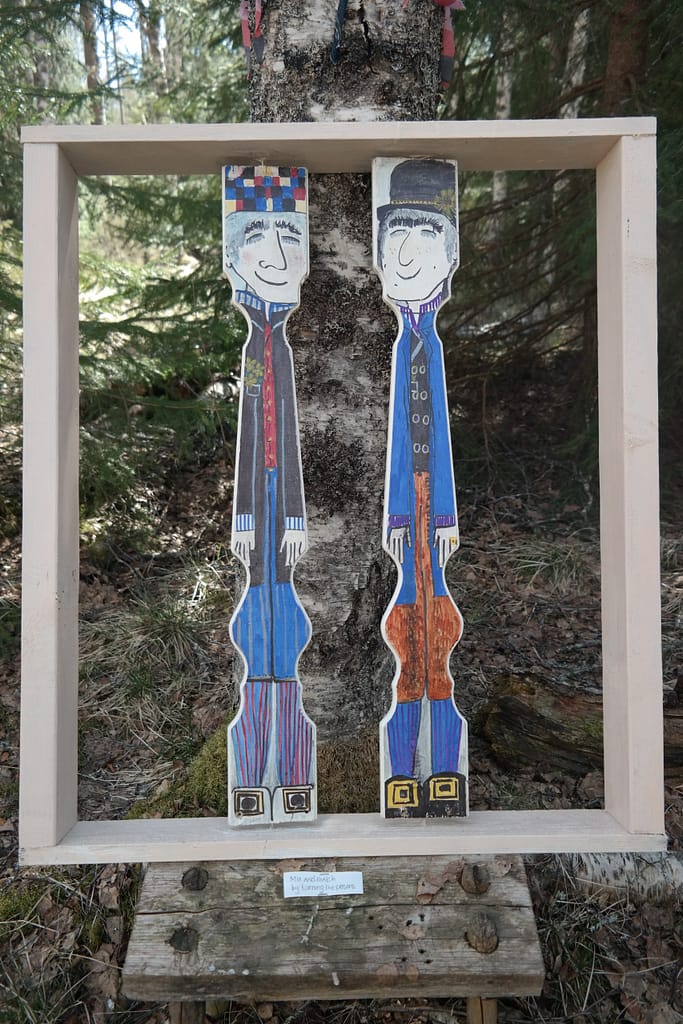 Inramad utomhusinstallation på druidstigen där besökare kan rotera träfigurer för att skapa olika par (man-man, kvinna-kvinna, man-kvinna) som en symbol för inkludering